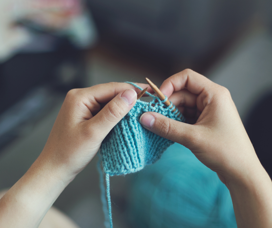 hier ist eine Person zu sehen, die mit blauem Garn strickt.